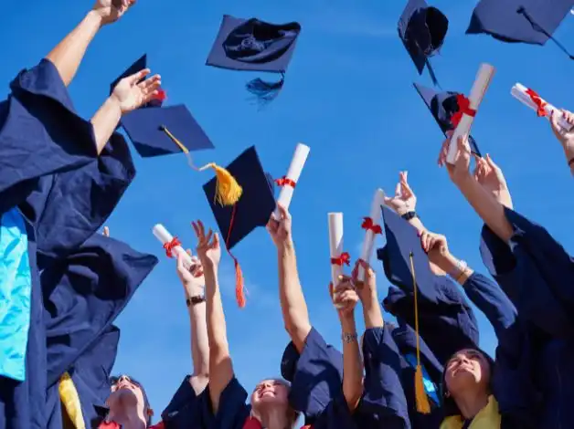 Graduating students in caps and gowns celebrating by tossing caps in the air